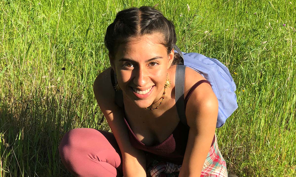 Staff Spotlight photo of Jesica Rodriguez sitting in the grass smiling